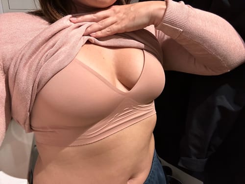 Syvara Komfort-BH in Beige unter einem rosa Pullover.